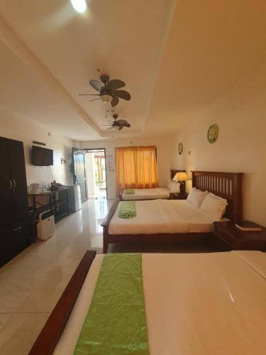 a hotel room with two beds and a kitchen at Moalboal Tropics in Moalboal