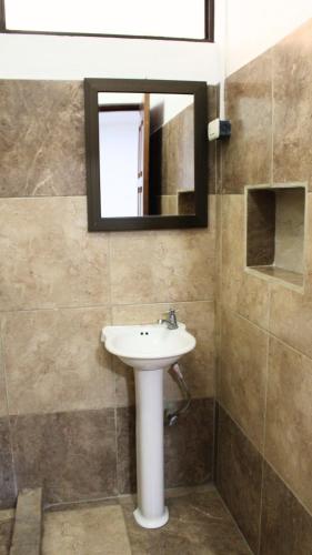 a bathroom with a sink and a mirror at Coconut Beach House in Playa Conchal