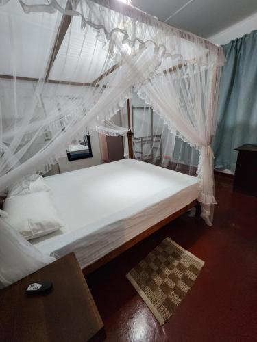 una camera con letto e zanzariera bianca di Ruwanwali Villa a Anuradhapura