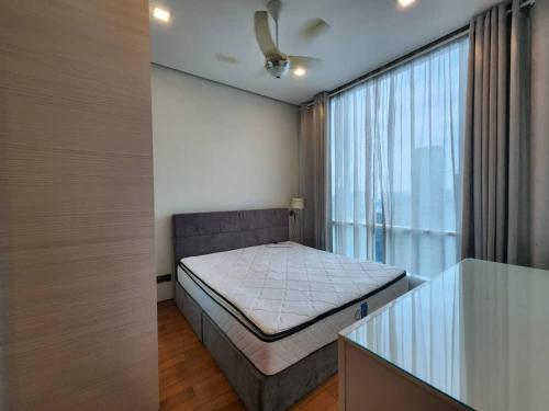 une petite chambre avec un lit et une fenêtre dans l'établissement Soho Suites KL City Centre, à Kuala Lumpur