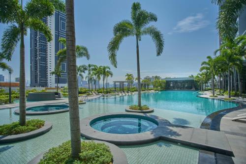 a swimming pool with palm trees in a resort at Trion Kuala Lumpur by Cobnb in Kuala Lumpur