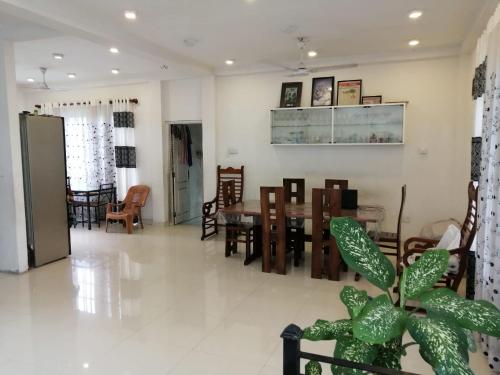 uma sala de jantar e sala de estar com mesa e cadeiras em Five Bed two-storey luxury House in 44 perch land in Bandaragama, Sri Lanka em Bandaragama