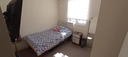 - une petite chambre avec un lit et une fenêtre dans l'établissement Departamento amoblado por día. Villa Alemana, à Villa Alemana