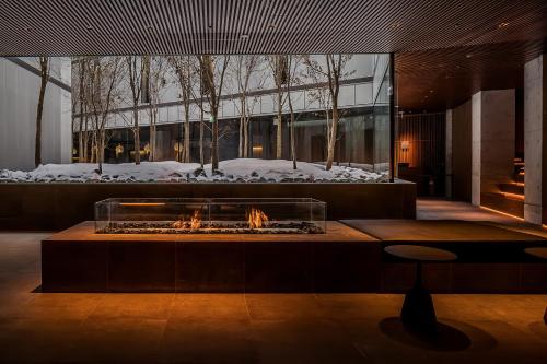 a fire pit in a lobby with snow on the ground at MUWA NISEKO in Kutchan