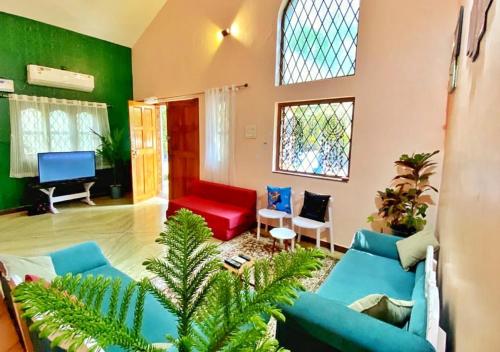 a living room with a red and blue couch at THE MUSAFIR HOSTEL in Anjuna