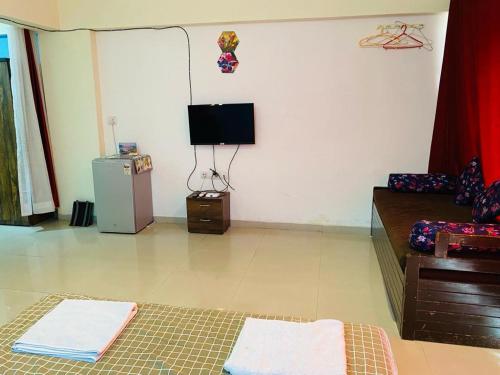 a living room with a refrigerator and a tv at Lake View Lavish studio in Lavasa