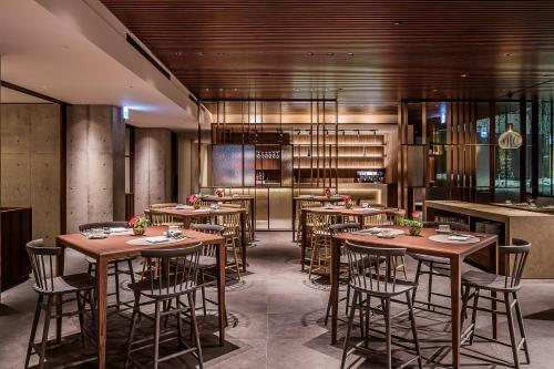 a restaurant with wooden tables and chairs and a kitchen at MUWA NISEKO in Kutchan