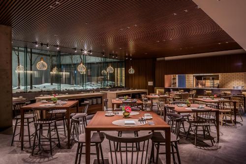 a restaurant with tables and chairs and a bar at MUWA NISEKO in Kutchan