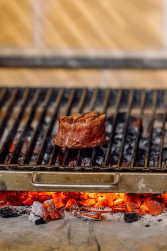 a piece of meat on a grill with fire at MUWA NISEKO in Kutchan