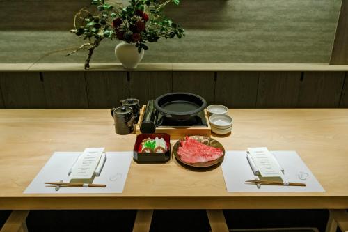 a table with chopsticks and a plate of meat on it at MUWA NISEKO in Kutchan