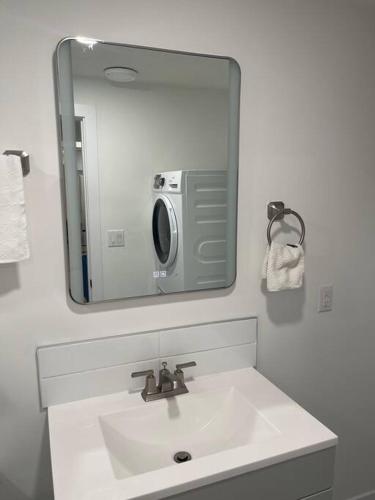 a bathroom sink with a mirror and a microwave at Modern 2Bedroom suite in SW Edmonton close to Edmonton International Airport in Edmonton