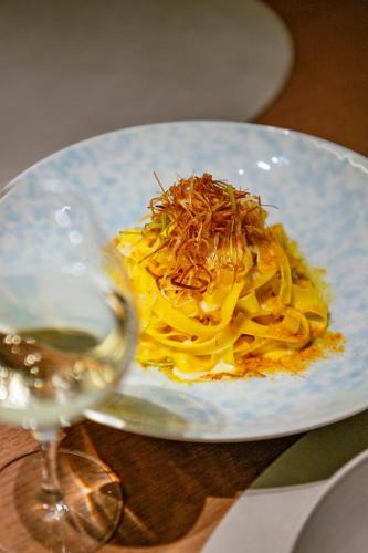 a plate of pasta and a glass of wine at MUWA NISEKO in Kutchan