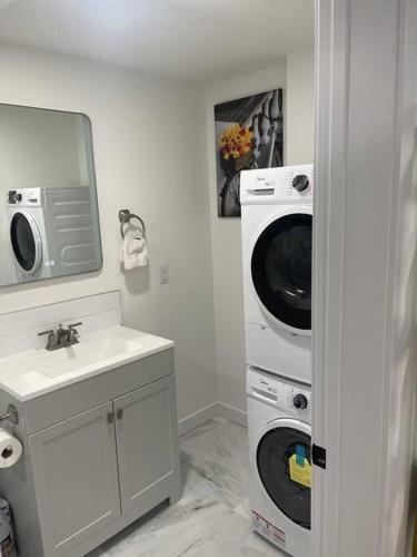 a bathroom with a washing machine and a sink at Modern 2Bedroom suite in SW Edmonton close to Edmonton International Airport in Edmonton