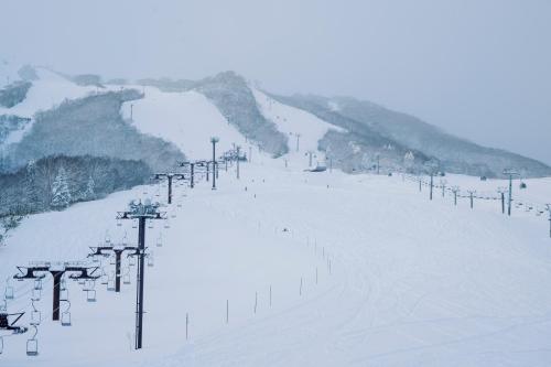 a snow covered ski slope with a ski lift at MUWA NISEKO in Kutchan