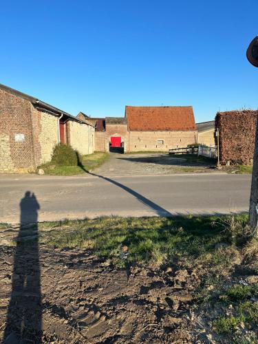 a shadow of a person standing on the side of a road at Ferme d’Herlaimont in Chapelle-lez-Herlaimont
