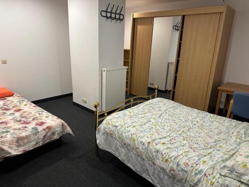 a hotel room with two beds and a mirror at Ferme d’Herlaimont in Chapelle-lez-Herlaimont