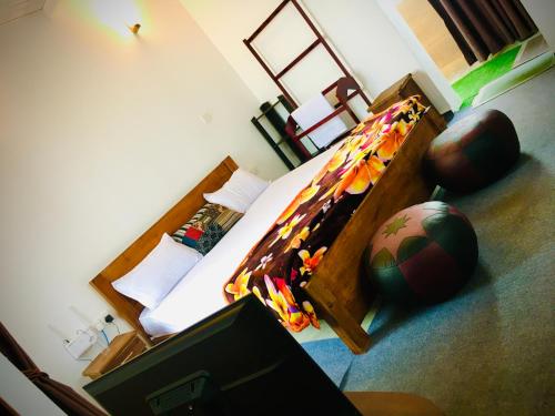 a bedroom with a bed and a soccer ball on the floor at Aquaa Leaf Residences in Nuwara Eliya