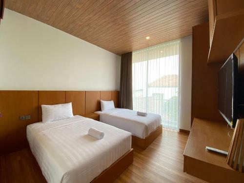 een hotelkamer met 2 bedden en een flatscreen-tv bij Casasola in Canggu
