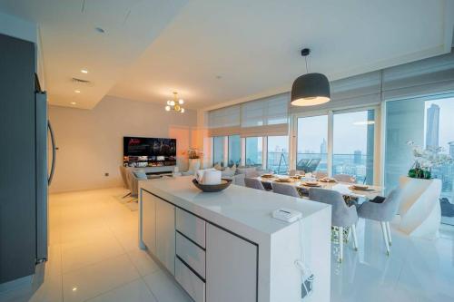 a kitchen and living room with a table and chairs at FIRST CLASS 3BR with Dubai Marina & Palm View in Dubai