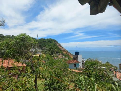 a view of a hill with the ocean in the background at Bem Me Quer Casas in Morro de São Paulo