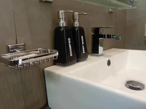duas garrafas pretas em cima de um lavatório de casa de banho em The Ritz Hikkaduwa em Hikkaduwa