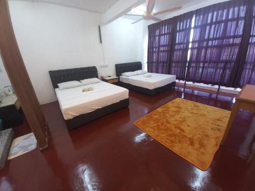 ein Wohnzimmer mit 2 Betten und einem Teppich in der Unterkunft Musafir Transit Hotel in Nilai