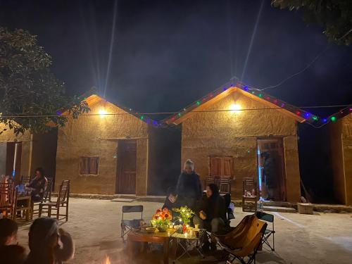 Ein Mann steht nachts vor einem Gebäude in der Unterkunft Nhằm Homestay in Ha Giang