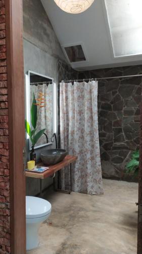 a bathroom with a toilet and a shower curtain at Villa di Bukit Lawang: LocalDailyLife, near Jungle in Bukit Lawang