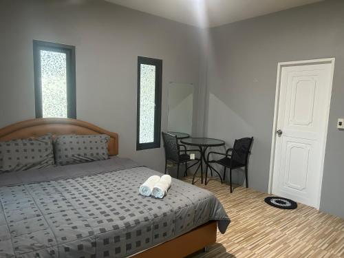 a bedroom with a bed and a table and chairs at WildernessMountain View in Ban Thung Ta In