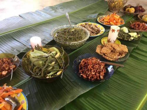 a table with plates of food on a banana leaf at Villa di Bukit Lawang: LocalDailyLife, near Jungle in Bukit Lawang