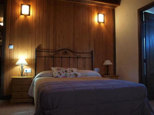 a bedroom with a large bed and two lights on the wall at EGO House in Panama City