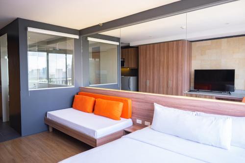 a room with a bed and a couch and a tv at Azumi Boutique Hotel in Manila
