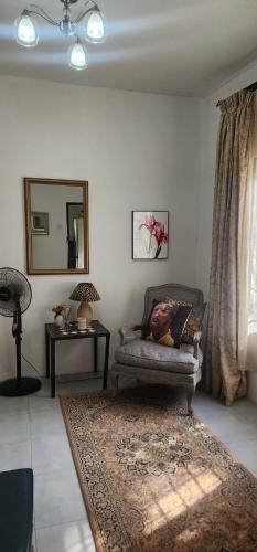een woonkamer met een stoel en een spiegel bij Treegate HMS Gardens in Lusaka