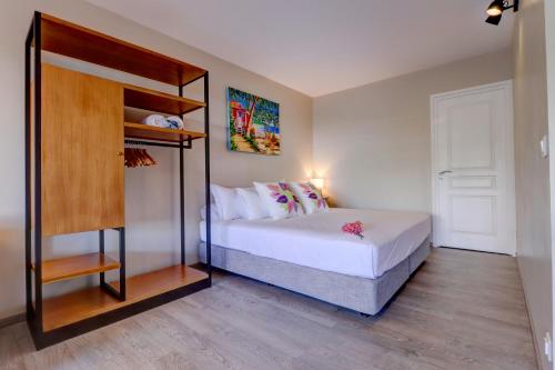 a bedroom with a bed and a book shelf at Premium suite proche aéroport, Wifi, Piscine, Parking in Faaa