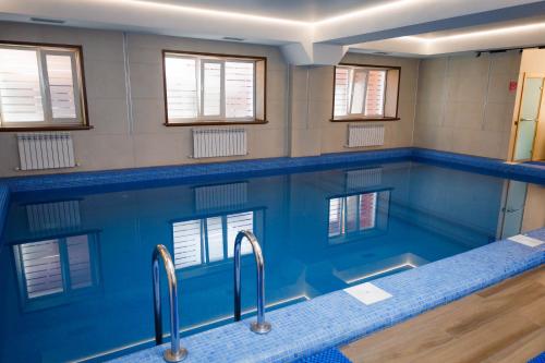 a bathroom with a tub with blue walls and windows at Eco hotel & restaurant "SKALA" in Borovoye