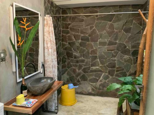 a bathroom with a stone shower with a sink at Villa di Bukit Lawang: LocalDailyLife, near Jungle in Bukit Lawang