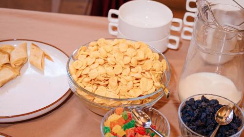 a table topped with bowls of food and milk at Eco hotel & restaurant "SKALA" in Borovoye
