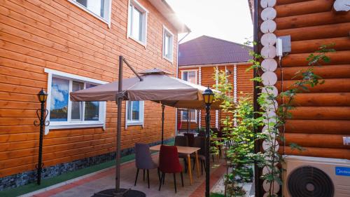 a table with an umbrella next to a building at Eco hotel & restaurant "SKALA" in Borovoye