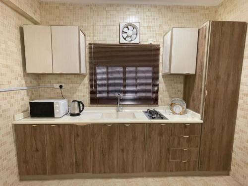 a kitchen with a sink and a microwave at مرفق هجرة السياحي الخاص in Al Madinah