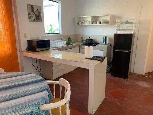 cocina con escritorio, microondas y nevera en Casa amarilla PH depa 2dorm 3er piso, en Punta Hermosa