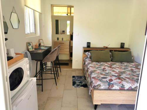 1 dormitorio con cama, escritorio y lavamanos en Fare Kairos en Uturoa