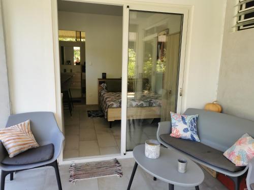 a living room with a couch and chairs and a bed at Fare Kairos in Uturoa