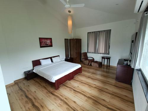 una camera da letto con un letto e un pavimento in legno di The HighGarden Resort a Udaipur