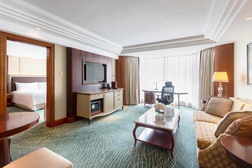 a living room with a couch and a tv at Kowloon Shangri-La, Hong Kong in Hong Kong