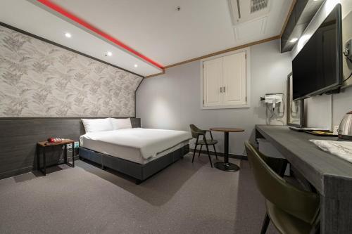 a small room with a bed and a kitchen at Signature Tourist Hotel in Seoul