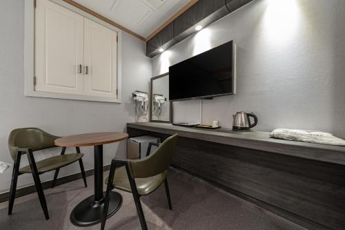 a room with a counter with a table and a television at Signature Tourist Hotel in Seoul