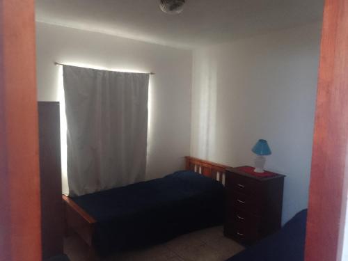 a bedroom with a bed and a dresser and a window at Hospedaje BellaVilla in Bell Ville