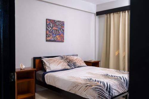 1 dormitorio con 1 cama con una pintura en la pared en Croton House, Nadi, en Nadi