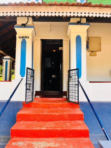 a red stairway leading to a black door at Srivilas in Pudunagaram