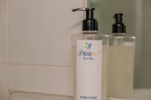 two bottles of soap sitting next to a mirror at Broadway Boston in Cape Town